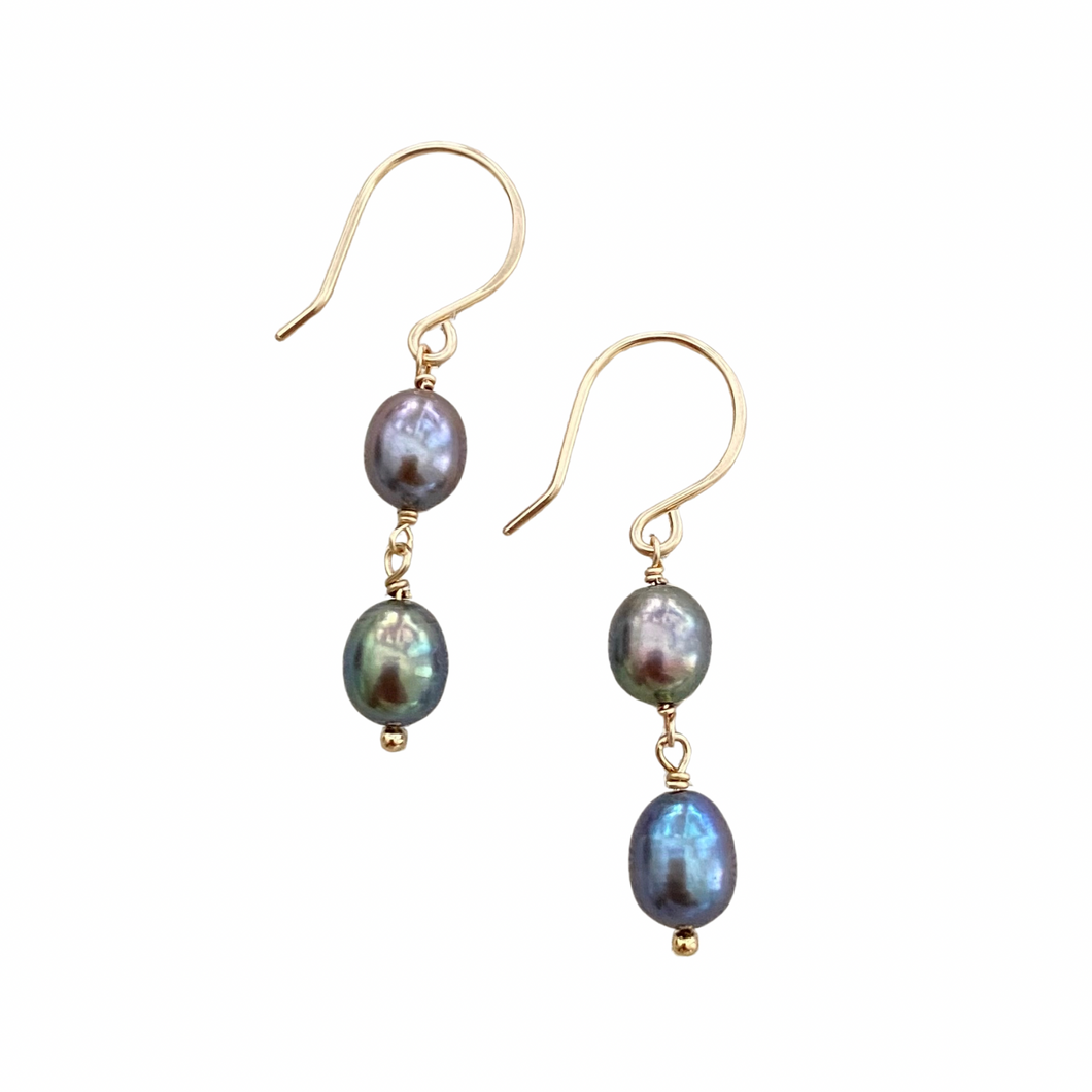 Pair of pearl earrings with gold hooks on a white background